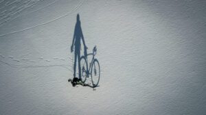 a shadow of a person riding a bike on snow